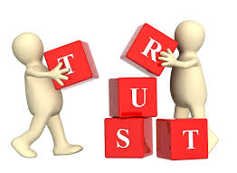 generic human images with building blocks spelling the word "trust:"